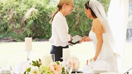 Wedding planner discussing plans with bride on wedding day