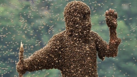 man covered in bees