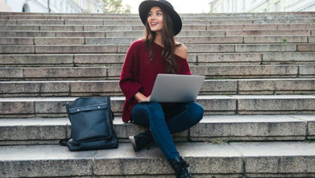 Young woman on stairs with laptop