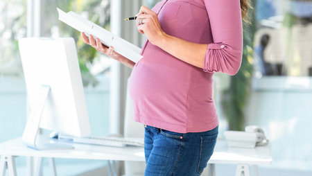 Pregnant woman worker writing maternity letter