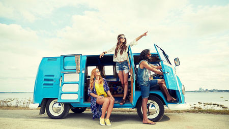 Group of young people travelling in a blue minivan