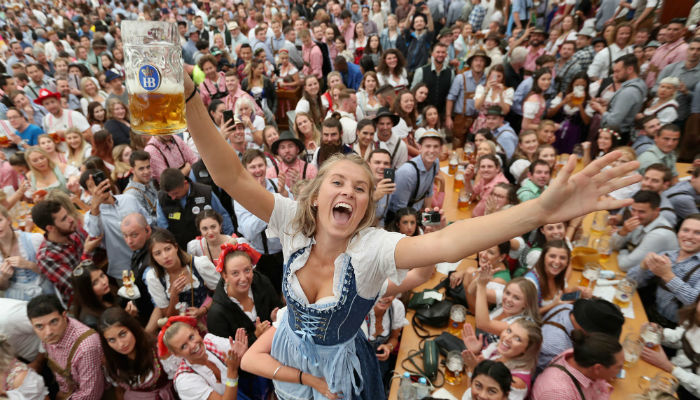 A happy woman drinking beer during Oktoberfest