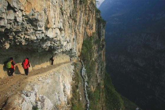 Image of children walking along a tight path in a mountainous region 