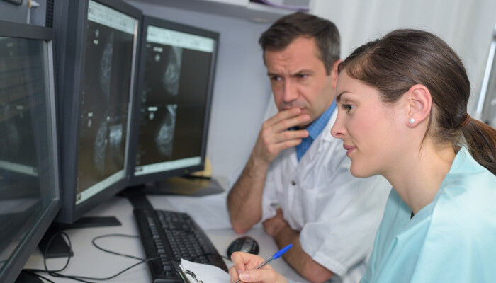 A male and female scientists looking at computer screens
