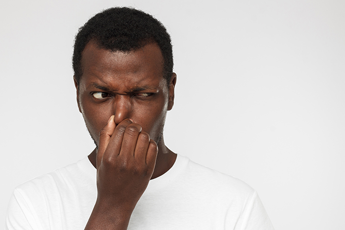 Odor tester plugging nose.
