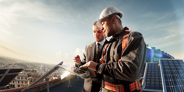 Solar thermal installer speaking with a client on the roof of a building