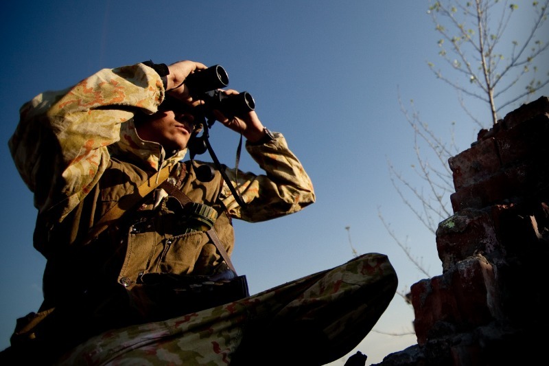 Artillery observer holding up binoculars 